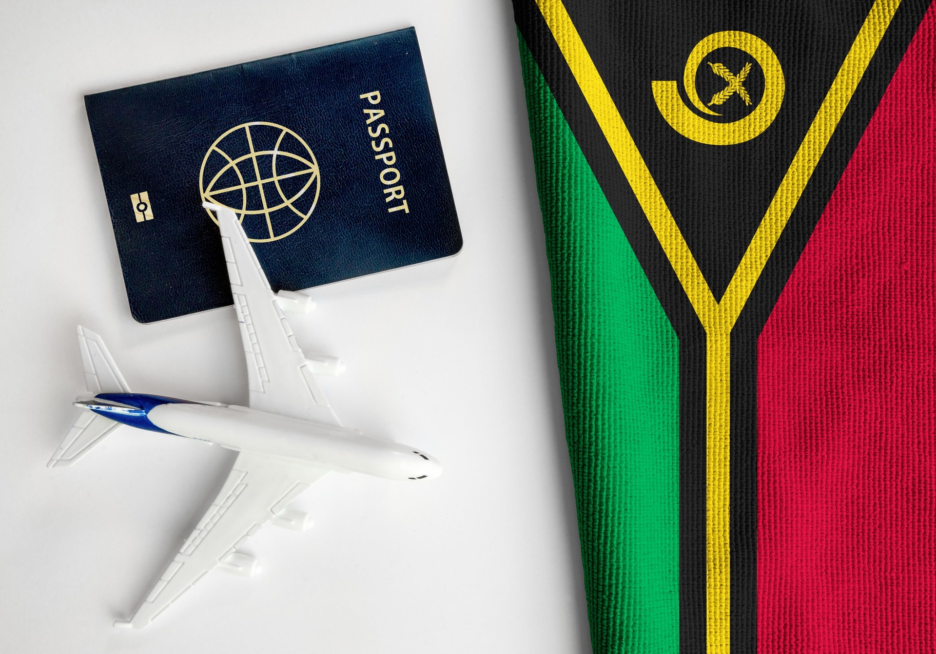 Flag of Vanuatu with passport and toy airplane.